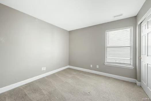 empty room with light carpet, visible vents, and baseboards