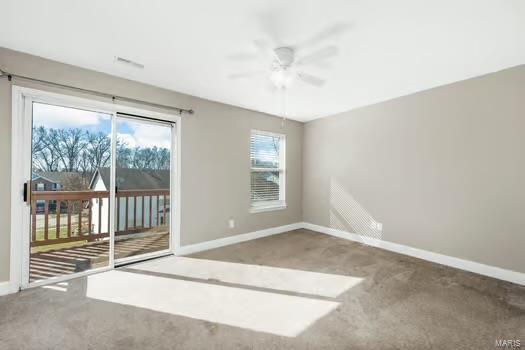 carpeted spare room with ceiling fan and baseboards