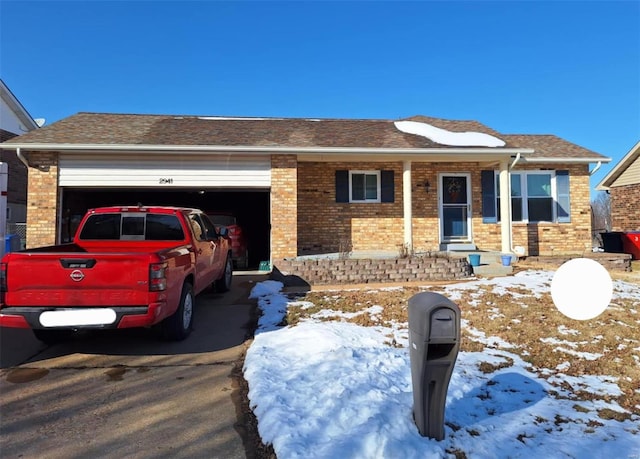 ranch-style home with a garage, driveway, and brick siding