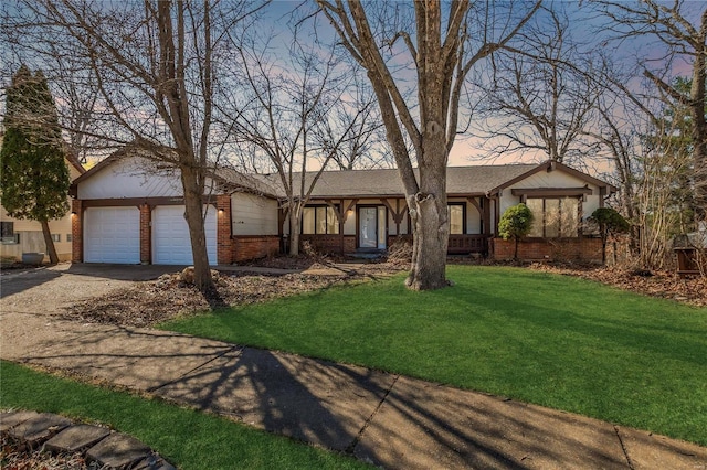 view of front of house with a garage, concrete driveway, brick siding, and a front lawn