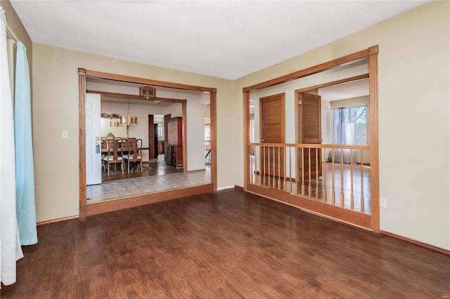 spare room featuring baseboards and wood finished floors