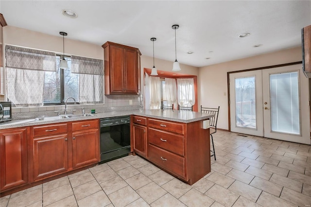 kitchen featuring tasteful backsplash, dishwasher, a peninsula, a kitchen bar, and pendant lighting