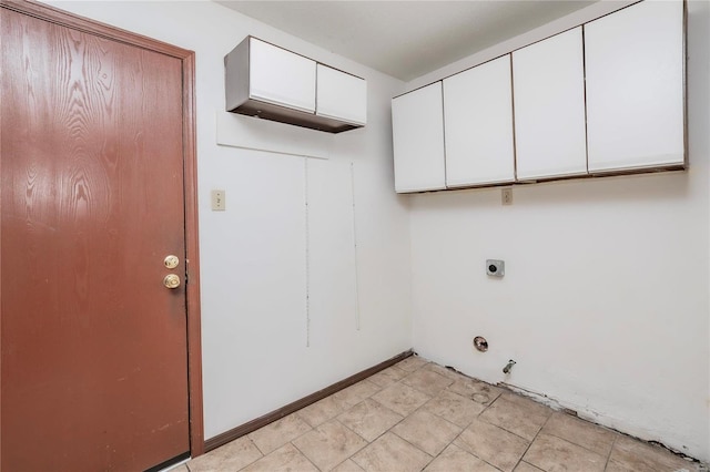 clothes washing area featuring hookup for a gas dryer, cabinet space, baseboards, and electric dryer hookup