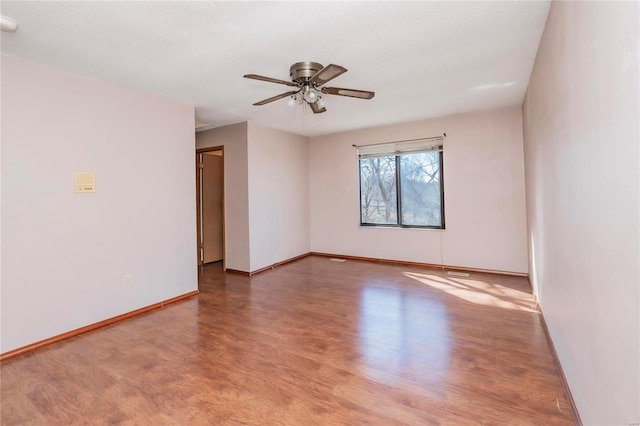 unfurnished room with ceiling fan, baseboards, and wood finished floors