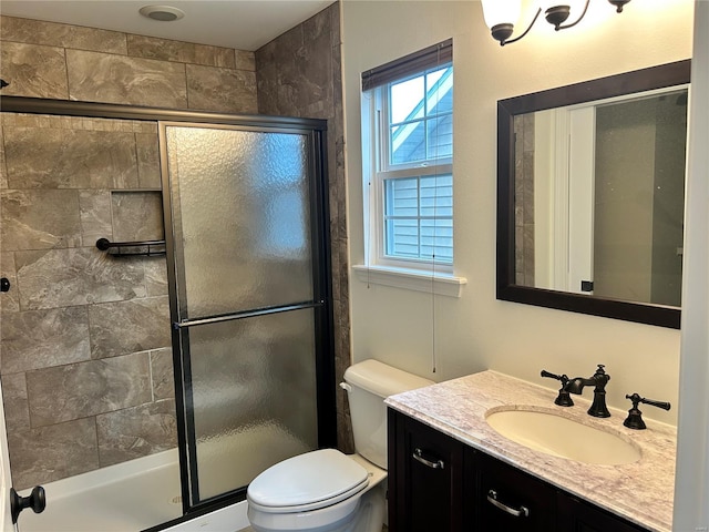 bathroom with toilet, vanity, and a stall shower