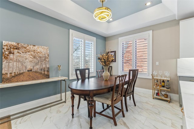 dining room with recessed lighting, marble finish floor, baseboards, and a tray ceiling