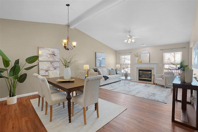 dining space with light wood-style floors, a wealth of natural light, and a glass covered fireplace