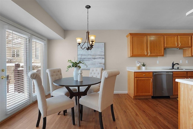 dining room featuring light wood-style floors, baseboards, and an inviting chandelier