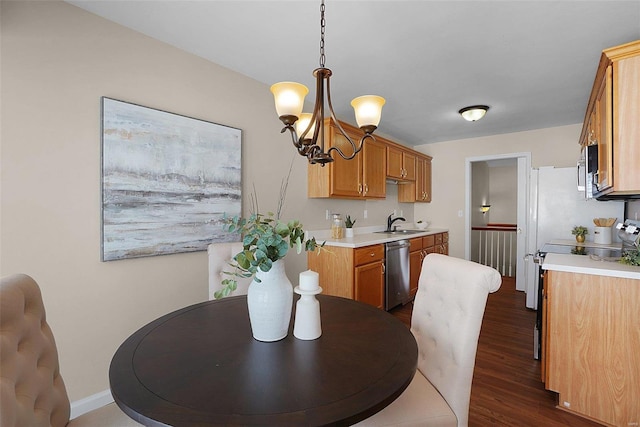 dining area with dark wood-style flooring, baseboards, and an inviting chandelier