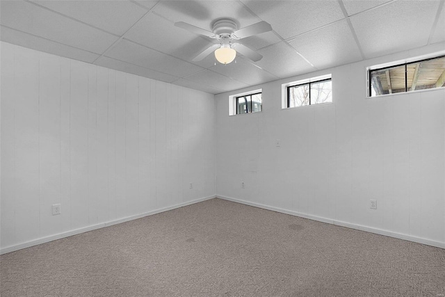 unfurnished room featuring ceiling fan, carpet, a paneled ceiling, and baseboards