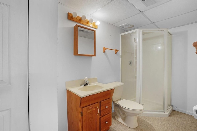 bathroom featuring a paneled ceiling, a shower stall, toilet, and vanity