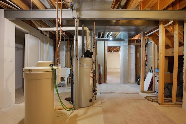 unfinished basement with gas water heater and a sink