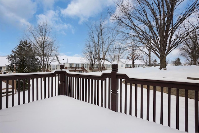 snow covered deck with a residential view