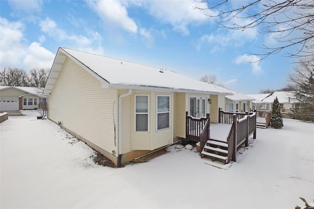 snow covered property with a deck