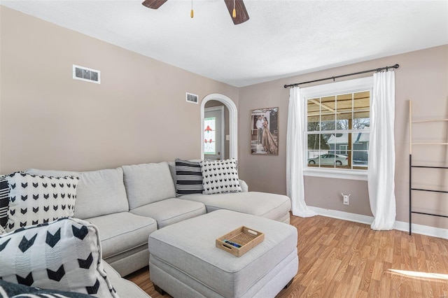 living area featuring light wood-style flooring, visible vents, and a healthy amount of sunlight