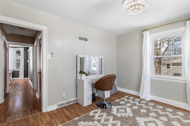 home office featuring visible vents, baseboards, and wood finished floors