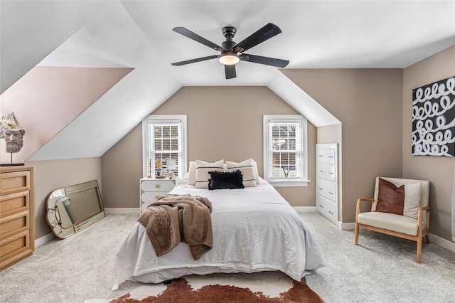 bedroom featuring lofted ceiling, baseboards, a ceiling fan, and light colored carpet