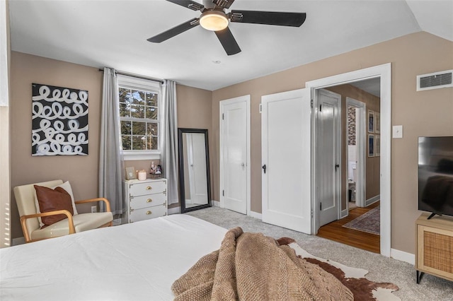 bedroom with ceiling fan, light colored carpet, visible vents, baseboards, and vaulted ceiling