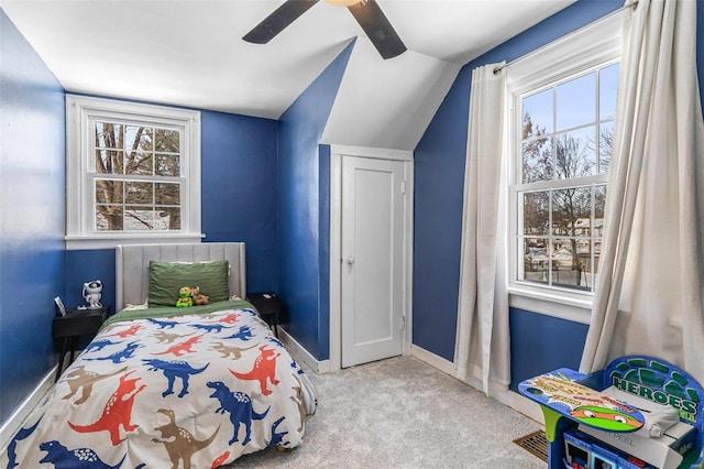 bedroom featuring light colored carpet, multiple windows, vaulted ceiling, and baseboards