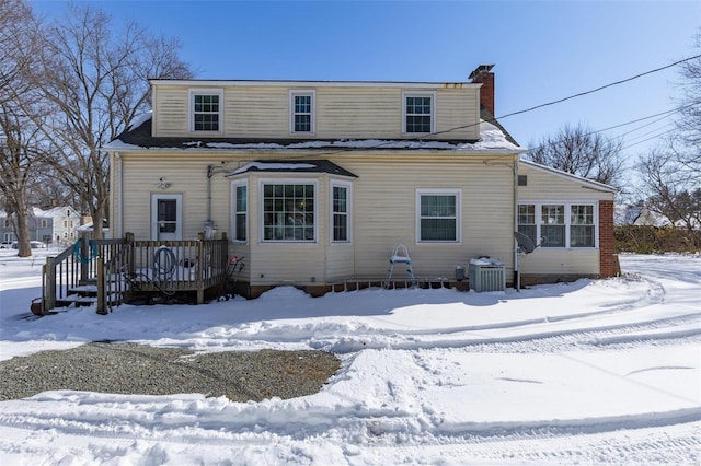 view of front of property with a chimney and central AC unit