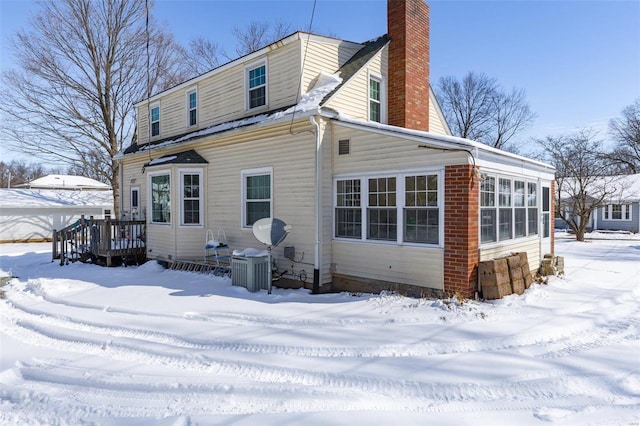 snow covered property with a chimney