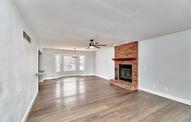 unfurnished living room with baseboards, a fireplace, visible vents, and wood finished floors