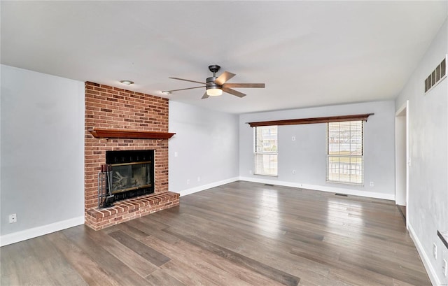 unfurnished living room featuring baseboards, a fireplace, visible vents, and wood finished floors