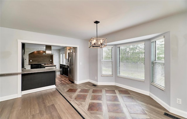 dining area featuring baseboards, visible vents, a chandelier, and wood finished floors