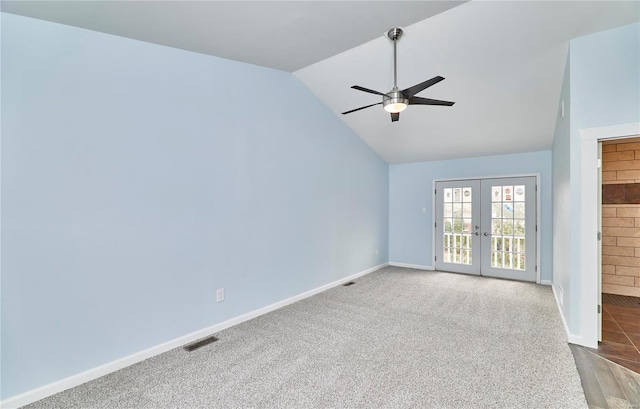 spare room with lofted ceiling, visible vents, baseboards, french doors, and carpet