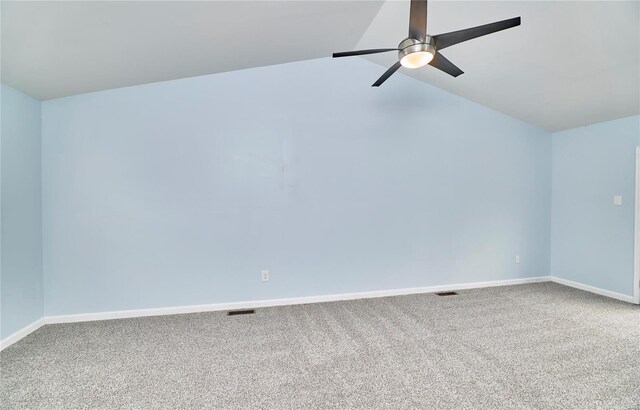 carpeted spare room featuring lofted ceiling, visible vents, ceiling fan, and baseboards