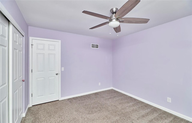 unfurnished bedroom featuring baseboards, visible vents, a ceiling fan, carpet flooring, and a closet