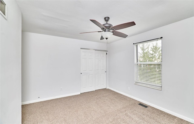 unfurnished bedroom with visible vents, baseboards, a ceiling fan, carpet, and a closet