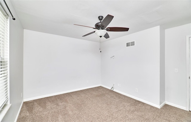 carpeted spare room with a ceiling fan, visible vents, and baseboards