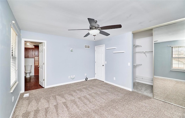 unfurnished bedroom with carpet, ensuite bath, visible vents, and baseboards