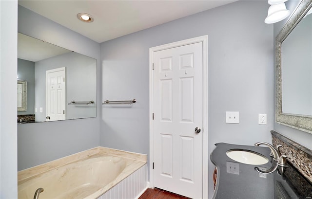 bathroom with a garden tub and vanity