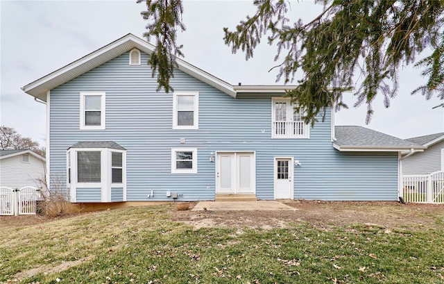 rear view of house featuring fence and a yard