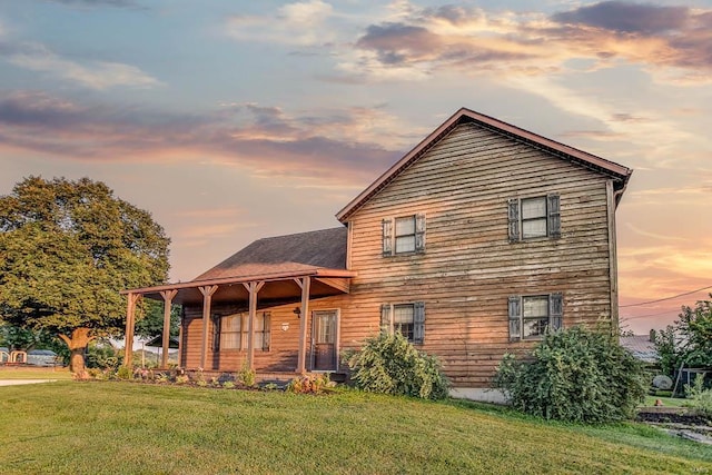 back of house with a porch and a lawn