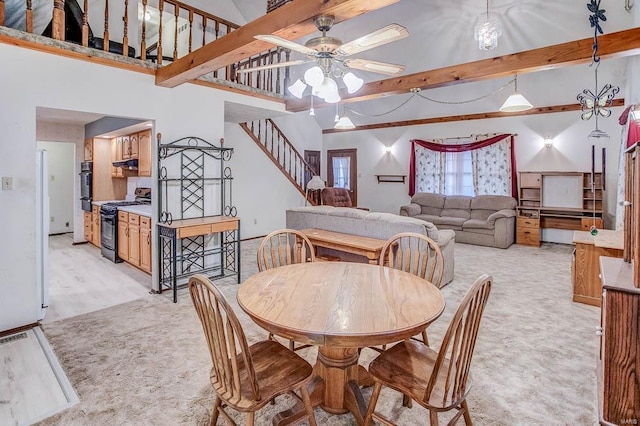 dining room with light carpet, ceiling fan, stairway, and beam ceiling