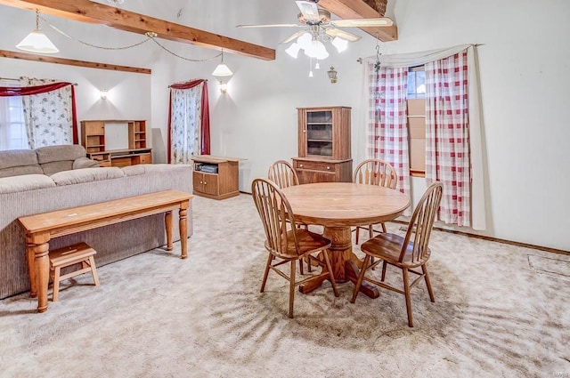 dining area featuring baseboards, a ceiling fan, beam ceiling, and light colored carpet