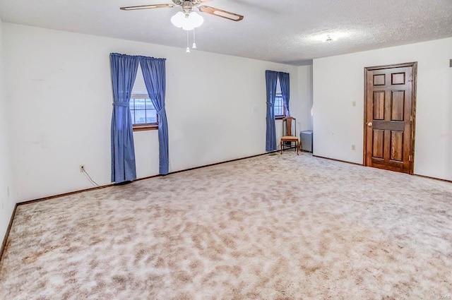 spare room featuring carpet, ceiling fan, a textured ceiling, and baseboards