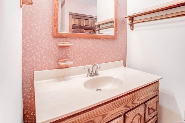 bathroom featuring wallpapered walls and vanity