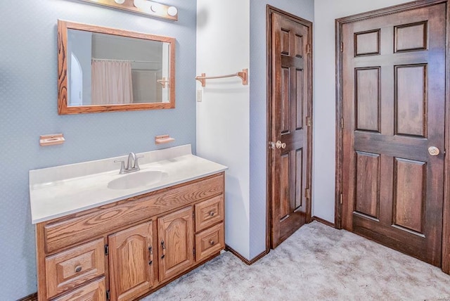 bathroom featuring carpet floors, vanity, and baseboards