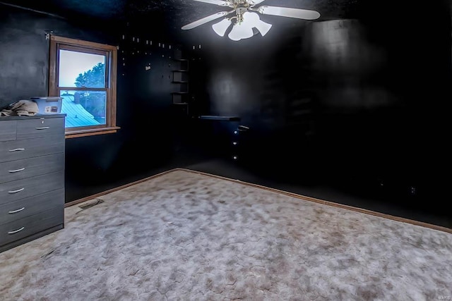 carpeted empty room with visible vents and a ceiling fan