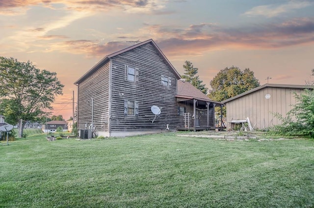 rear view of house with a lawn and cooling unit