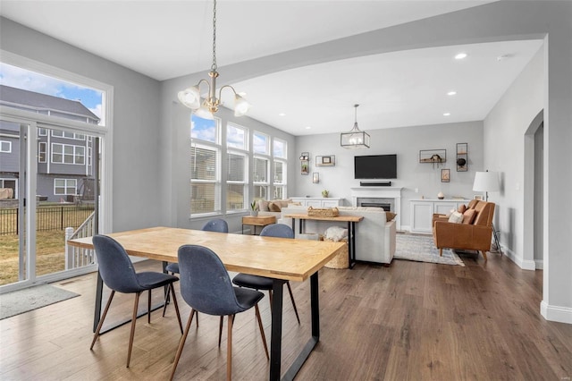 dining area featuring a fireplace, recessed lighting, baseboards, and dark wood-style flooring