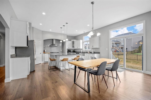 dining room featuring dark wood-type flooring, recessed lighting, and baseboards