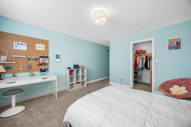 carpeted bedroom with a spacious closet, a closet, and baseboards