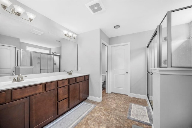 bathroom featuring double vanity, a stall shower, visible vents, and a sink