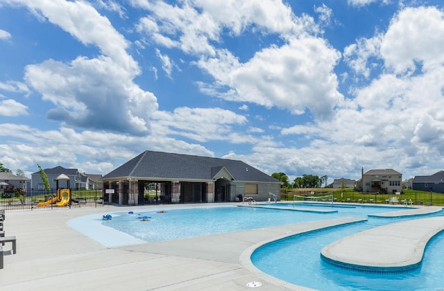 pool featuring playground community, a patio, and fence