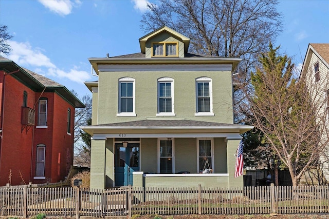 view of front of house featuring a fenced front yard, brick siding, and a porch